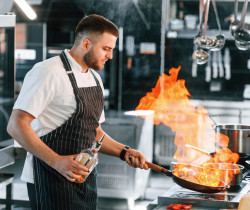 Chef cuisinier préparant un plat flambé