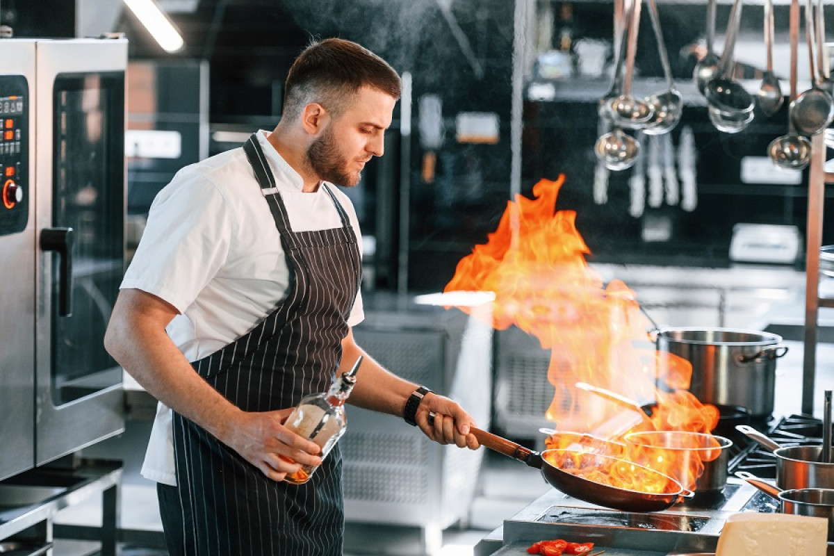 Chef cuisinier préparant un plat flambé