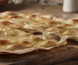 découvrez la focaccia di recco, une spécialité ligure délicieuse : une focaccia fine et croustillante garnie de fromage fondant, parfaite pour les amateurs de saveurs authentiques.